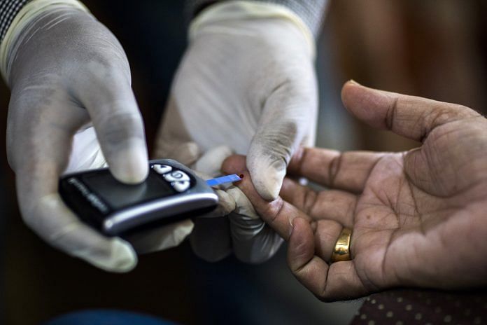 A Public Health Foundation of India worker conducts a blood glucose test for a patient | Prashanth Vishwanathan/Bloomberg