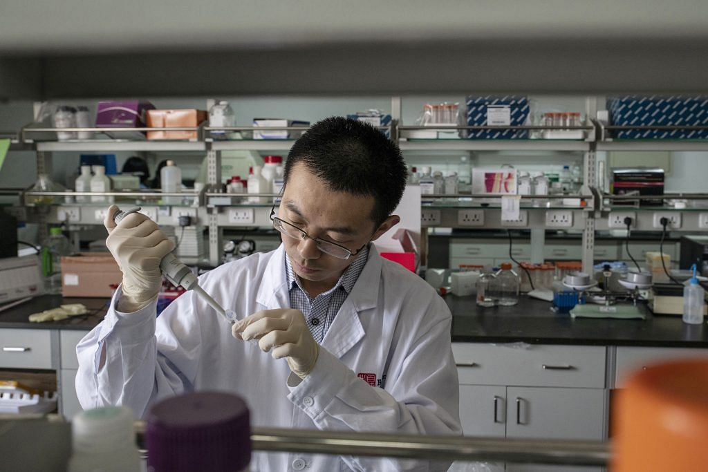 A researcher prepares a sample inside a laboratory ~ Gilles Sabrie/Bloomberg