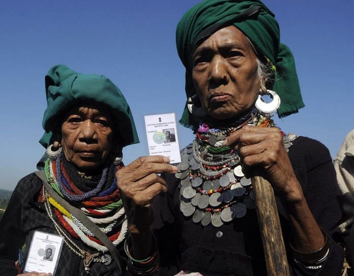 Bru tribe refugees hold up their voter identification cards | Getty Images