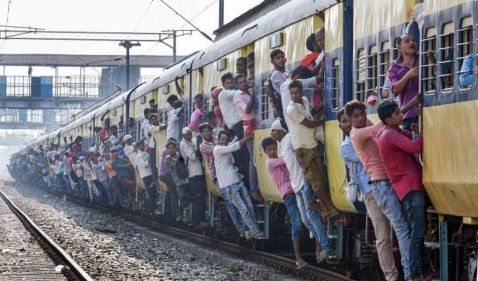 Commuters lean out of an overcrowded local train on the day of Railway Recruitment Board Examination (RRB), in Patna, Monday, September 24, 2018. | PTI