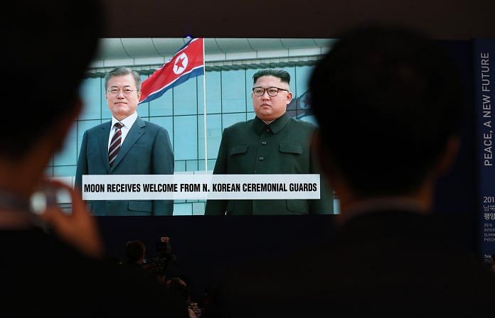 A screen showing a broadcast, featuring South Korean President Moon Jae-in meeting North Korean leader Kim Jong-un | Bloomberg