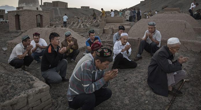 Uyghur men perform prayers in Xinjiang province, China | Kevin Frayer/Getty Images