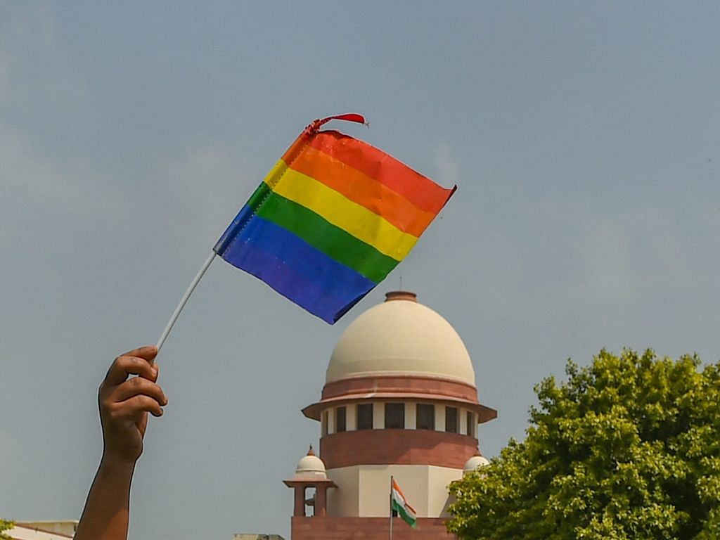 An activist waves a LGBT pride flag after the Supreme Court verdict | Kamal Kishore/PTI