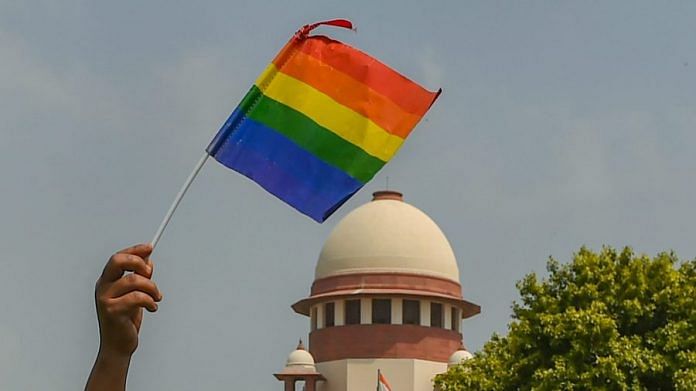 An activist waves a LGBT pride flag after the Supreme Court verdict | Kamal Kishore/PTI