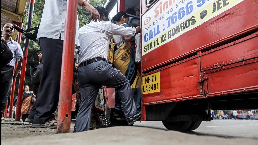 Commuters boarding a bus outside Chhatrapati Shivaji Terminus railway station | Dhiraj Singh/Bloomberg