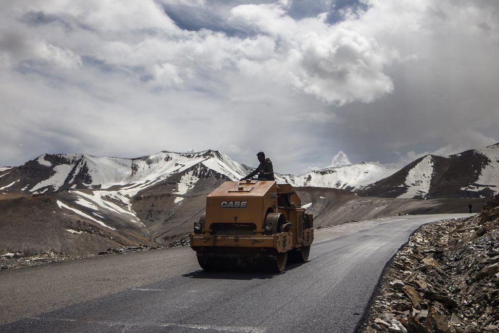A Border Roads Organisation (BRO) worker drives a steamroller while repairing a road surface with tarmac on a section of the Leh Manali highway in Ladakh region | Prashanth Vishwanathan/Bloomberg