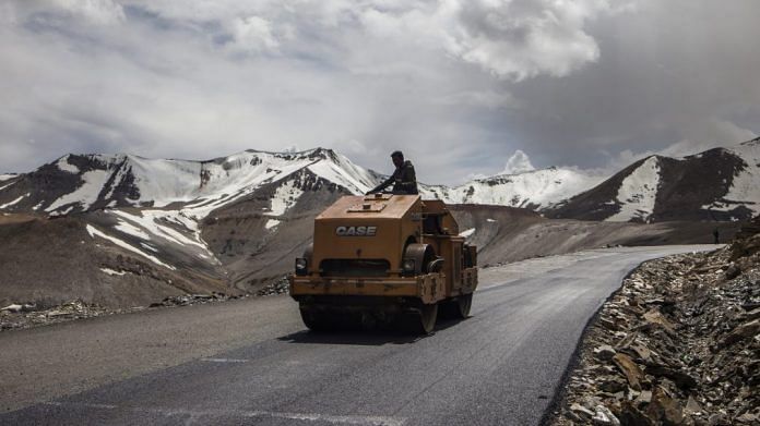 A Border Roads Organisation (BRO) worker drives a steamroller while repairing a road surface with tarmac on a section of the Leh Manali highway in Ladakh region | Prashanth Vishwanathan/Bloomberg
