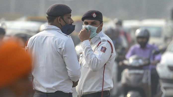 Traffic policemen wear masks to protect themselves as air quality deteriorates, in New Delhi