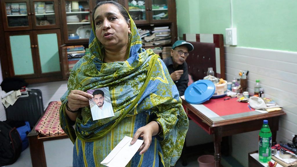 Najeeb’s mother Fatima Nafees and his father Naseer Ahmed show a photograph of their missing son | Manisha Mondal / ThePrint