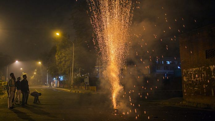 Revelers watch a firework during Diwali celebrations in Delhi | Prashanth Vishwanathan/Bloomberg