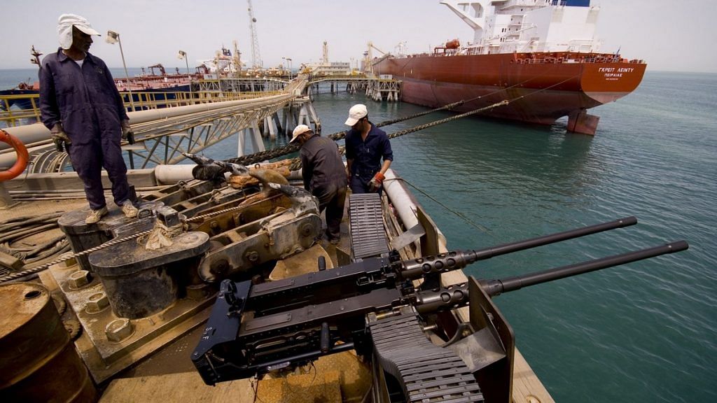 Iraqi oil workers secure the ropes of an oil tanker at Iraq's Al Basra oil terminal in the Northern Arabian Gulf