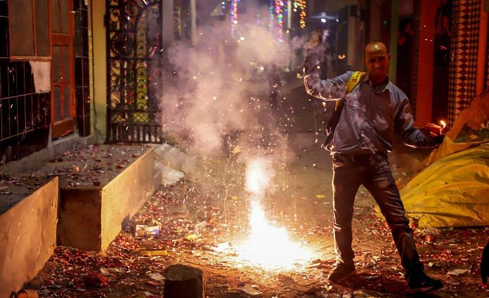 Smoke rises as people burn crackers during Diwali celebrations, in Gurugram