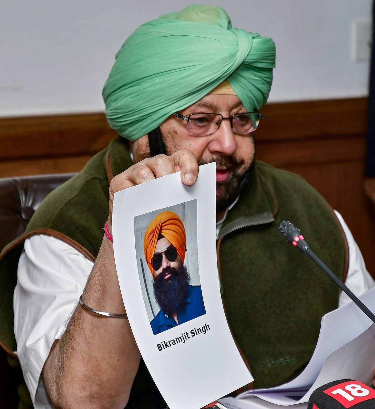 Punjab CM Capt. Amarinder Singh shows a picture of Amritsar grenade blast co-accused Bikramjit Singh during a press conference in Chandigarh | PTI