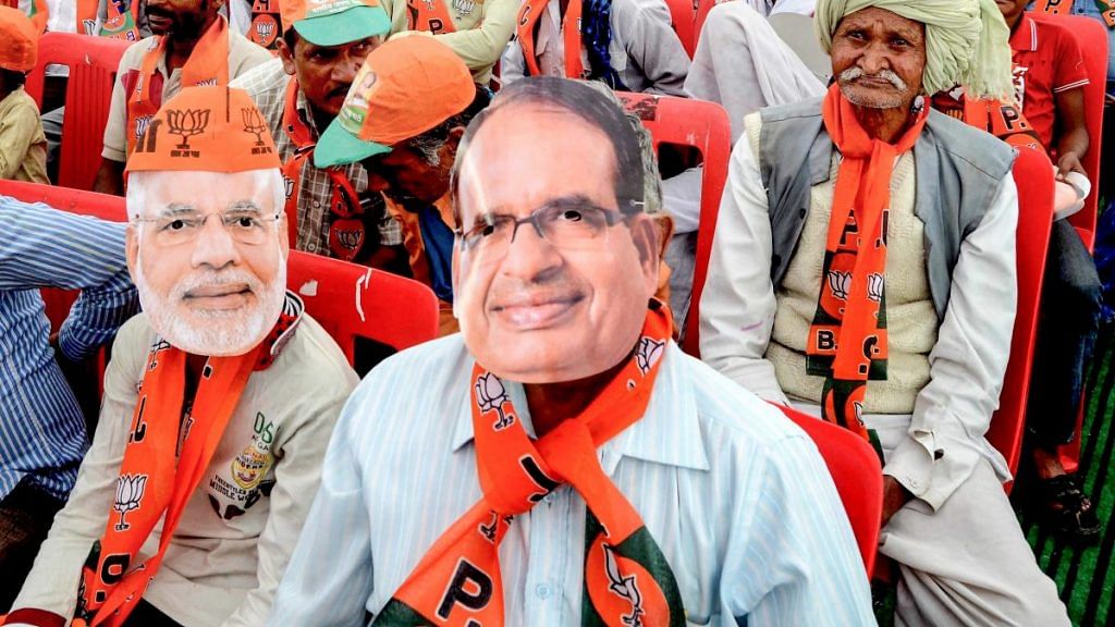 BJP supporters wear masks of PM Narendra Modi and CM Shivraj Singh Chouhan at an election rally in Bhopal | PTI