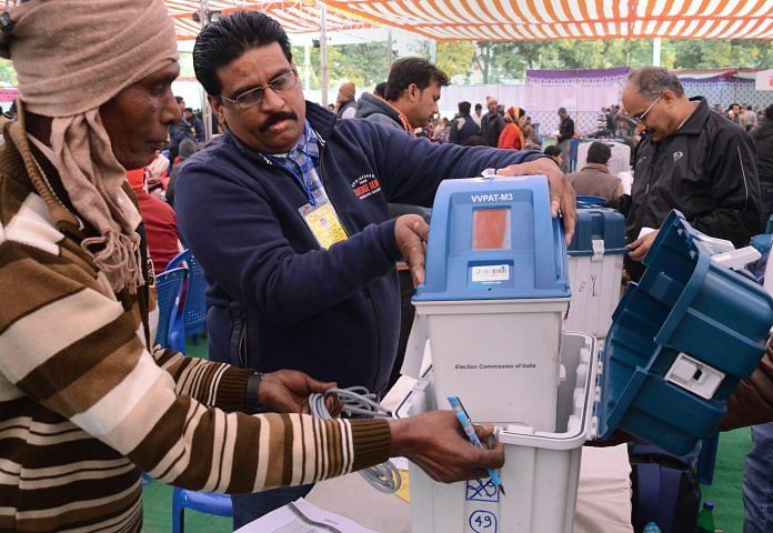Election officials collect their Electronic Voting Machine (EVM) from a distribution centre ahead of the Assembly elections in Jabalpur