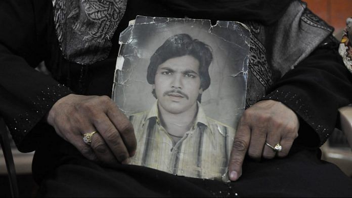 Zehbunisha shows a picture of her husband wife of Mohd Iqbal who was killed in 1987 Hashimpura massacre | Saumya Khandelwal/Hindustan Times via Getty Images