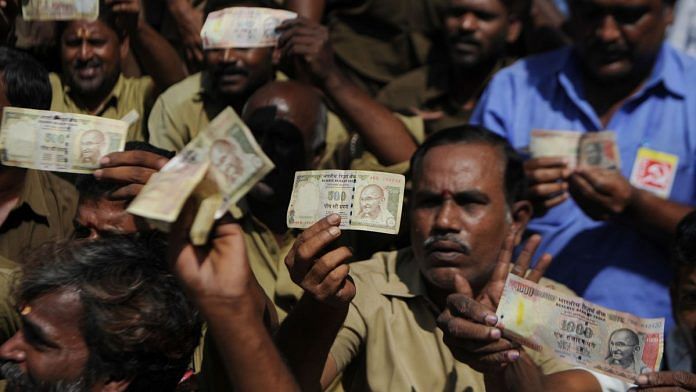 Indian trade union members pose for media holding banned currency notes during a demonstration against demonitisation in Chennai | Arun Sankar/AFP/Getty Images