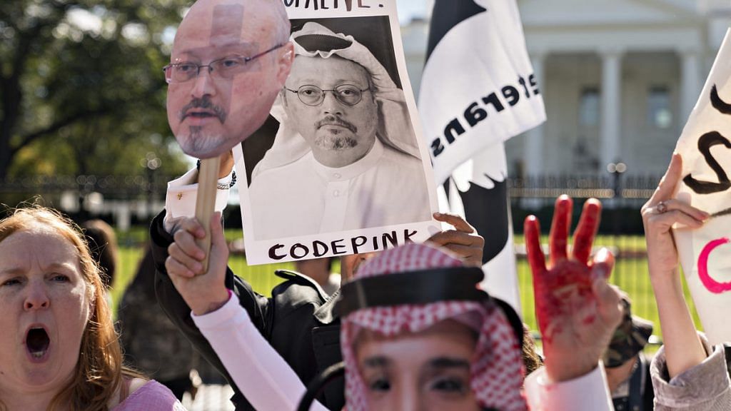 Protesters hold photographs of journalist Jamal Khashoggi outside the White House in Washington, D.C.|