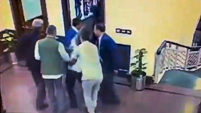 A still from a video posted by the AAP on its twitter account shows Anil Kumar being held after he allegedly threw chilli powder at Delhi CM Arvind Kejriwal | PTI