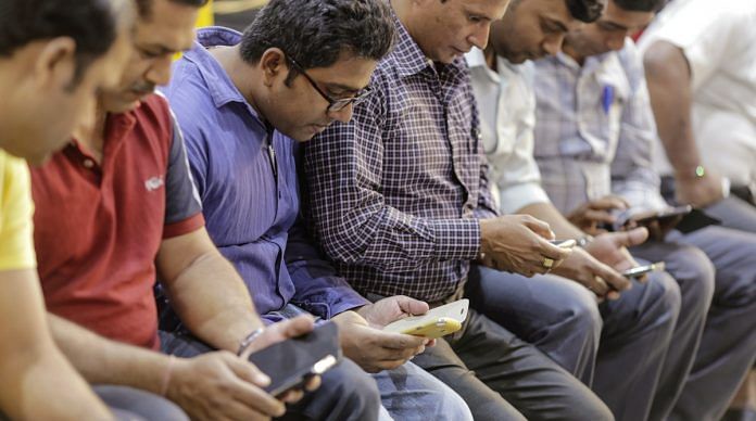 Passengers use smartphones at Mumbai Central railway station | Dhiraj Singh/Bloomberg