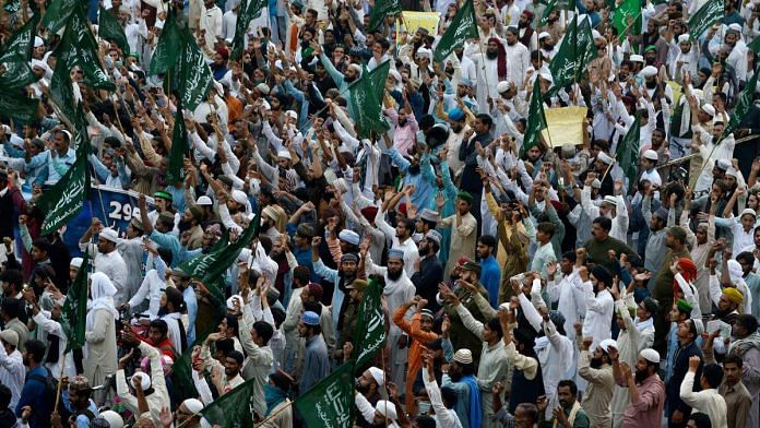 Supporters of Tehreek-e-Labbaik march during a protest in Lahore against the acquittal of Asia Bibi | ARIF ALI/AFP/Getty Images