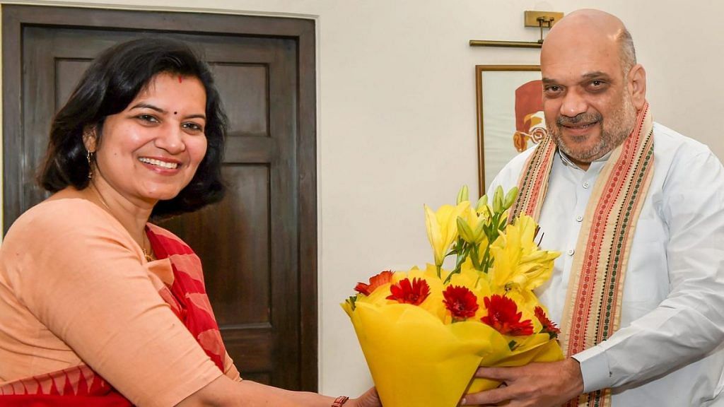 BJP President Amit Shah receives a bouquet from former IAS officer Aparajita Sarangi
