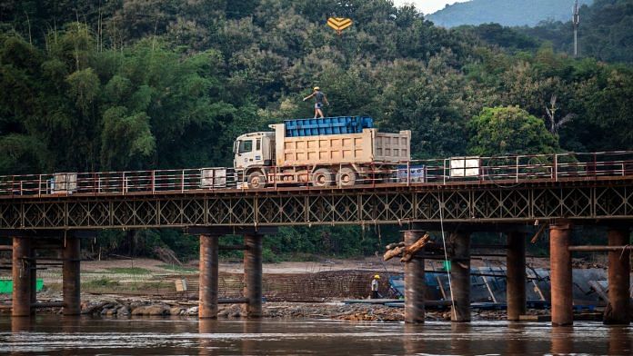 A worker walks atop a lorry on the construction site of the Ban Ladhan Railway bridge, a section of the China-Laos Railway | Taylor Weidman/Bloomberg