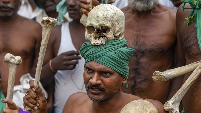 A farmer from Tamil Nadu display human skulls and bones during a protest ahead of their march towards Parliament