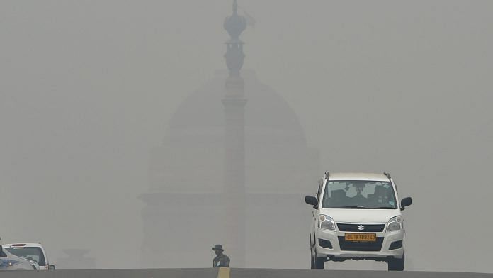 Commuters drive through heavy smog at Rajpath