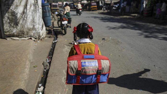 A girl goes to school | Dhiraj Singh/Bloomberg