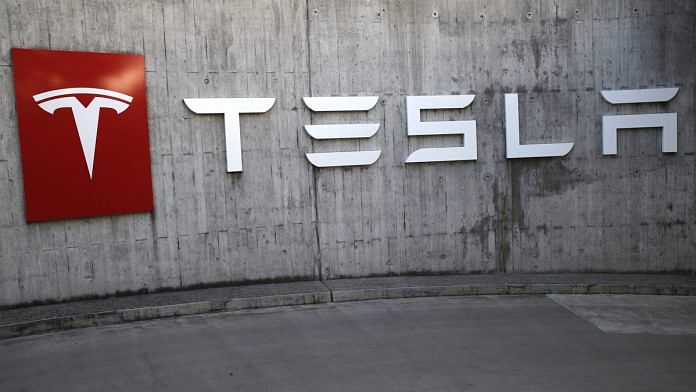 A company logo hangs outside a Tesla Inc. store in Bern, Switzerland