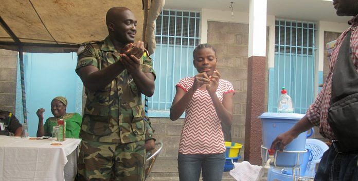 Fighting against Ebola in DR Congo: A MONUSCO Ghanaian peacekeeper showing a young girl how to properly wash hands