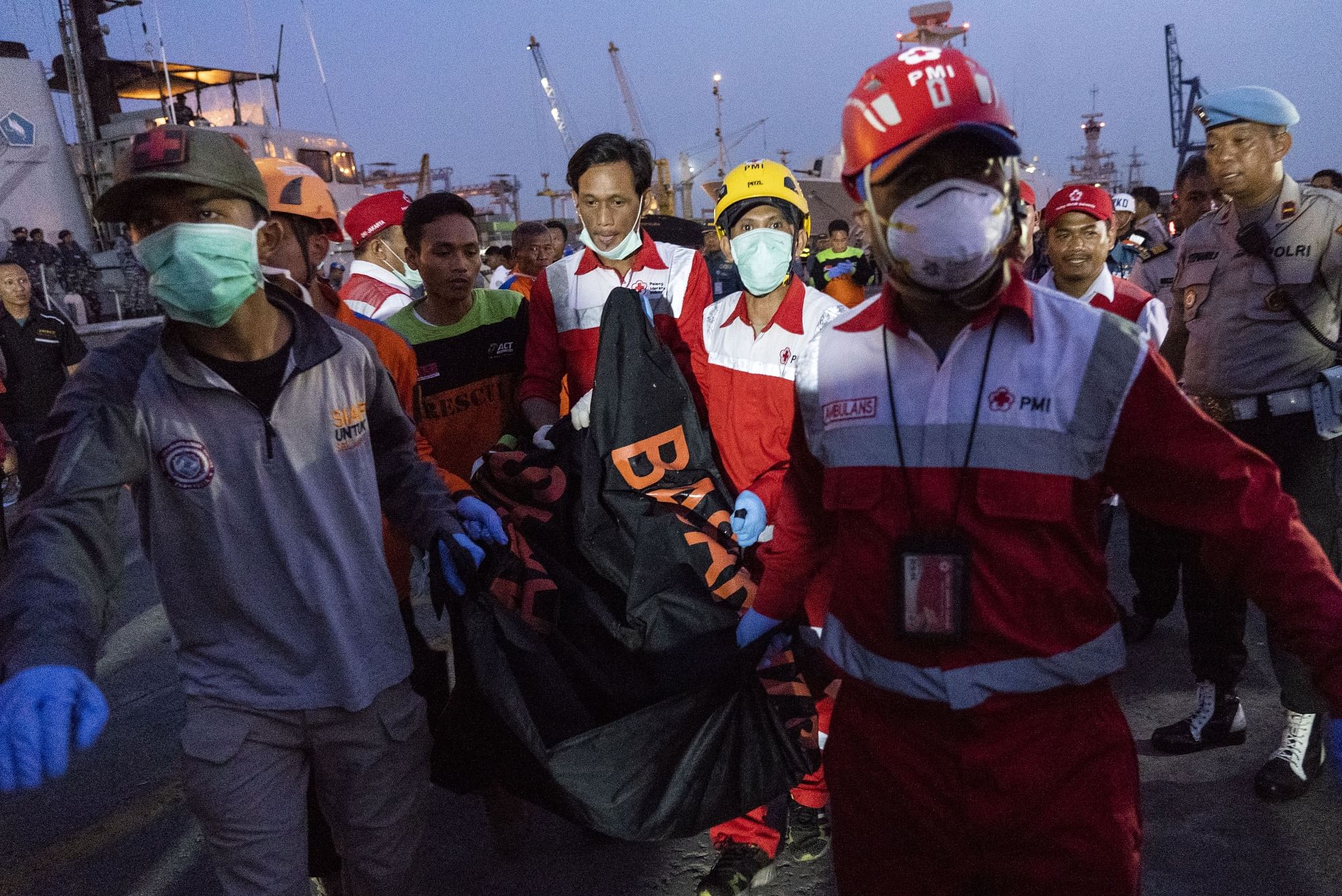 Search and rescue team members carry a body recovered from the crash | Rony Zakaria/Bloomberg