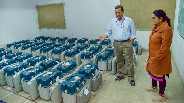 Election officials collect their Electronic Voting Machine from an EVM distribution centre ahead of the state Assembly elections in Ajmer | PTI