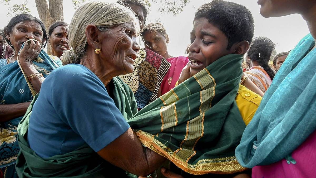 A boy being consoled by his grandmother after his mother died of suspected food poisoning at Bidarahalli, near Sulawadi village in Chamarajnagar district of Karnataka