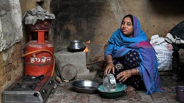 Woman prepares food on a chulha
