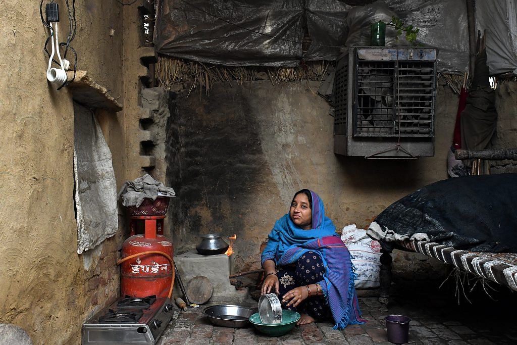 A woman prepares food to be cooked on a LPG-connected stove at her home in a village near Modinagar, Uttar Pradesh | Anindito Mukherjee/Bloomberg