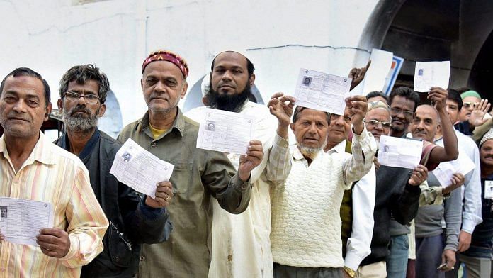 Voters in Bikaner show their identity cards as they wait to cast their vote for the state Assembly elections, in Bikaner on December 7, 2018 | PTI
