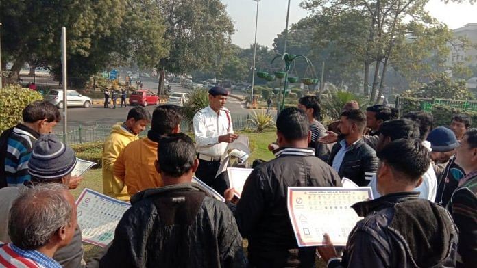 A Delhi police personnel distributes road safety pamphlets on 31 Dec | Facebook