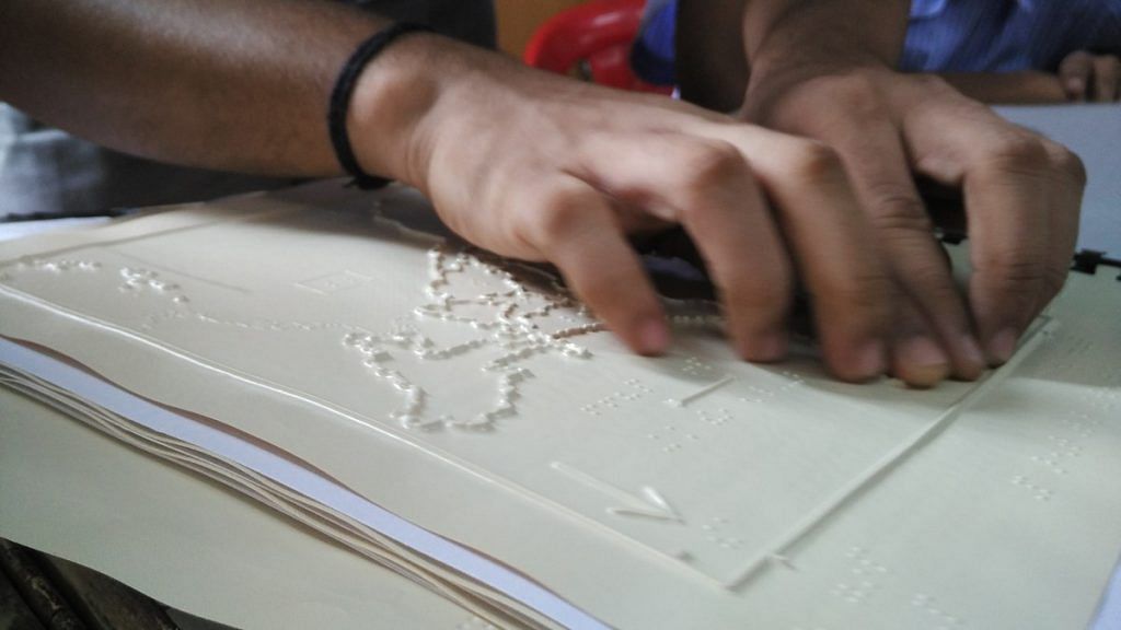 A visually impaired student studying a tactile graphic | By special arrangement