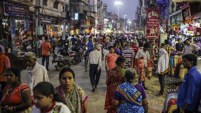 Pedestrians and shoppers walk past stores on a street in Varanasi (representational image) | Dhiraj Singh/Bloomberg