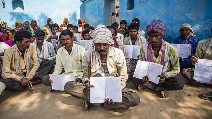 Villagers of Lar Sauryana in Madhya Pradesh show their job cards with no entries under MNREGA | Prashanth Vishwanathan/Bloomberg