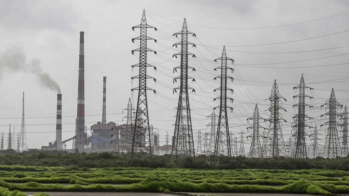 Smoke rises from a chimney as electricity pylons stand at the Tata Power Co. Trombay Thermal Power Station | Bloomberg