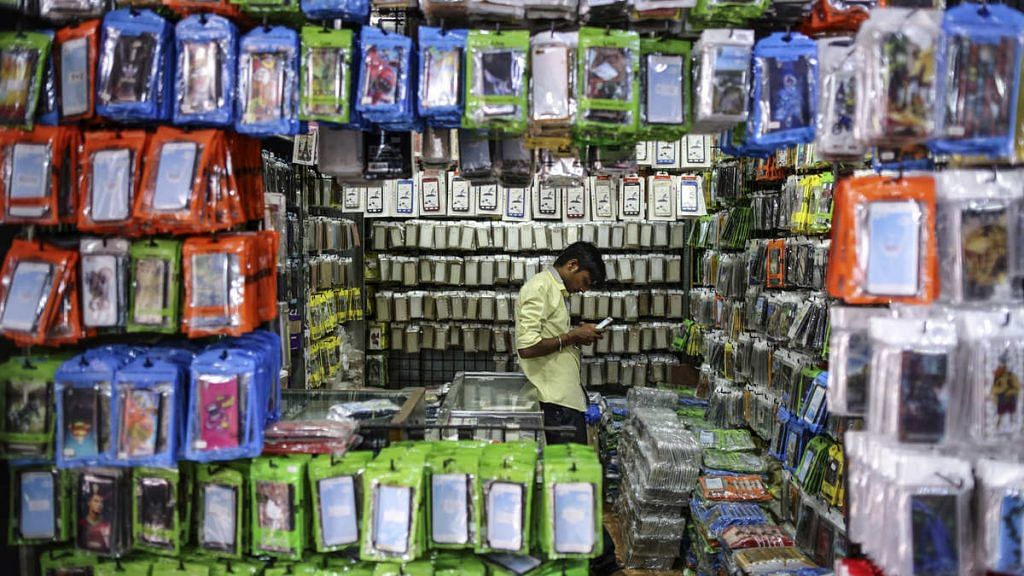 A vendor uses a smartphone at a wholesale stall selling mobile phone accessories (Representational image)