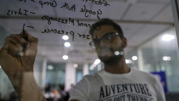 An employee uses a marker pen to write on glass wall