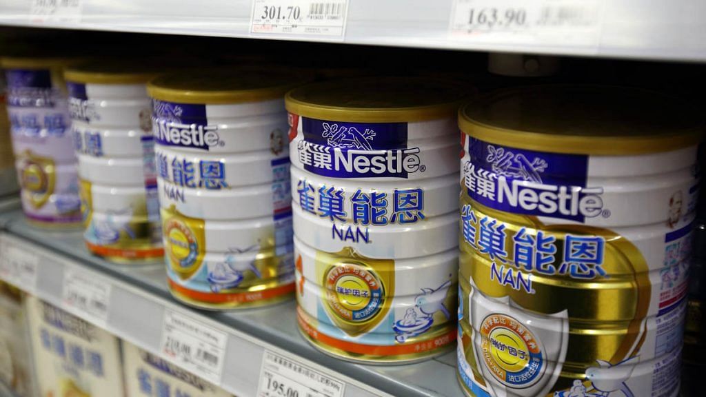 Cans of baby formula manufactured by Nestle SA sit on a shelf inside a supermarket