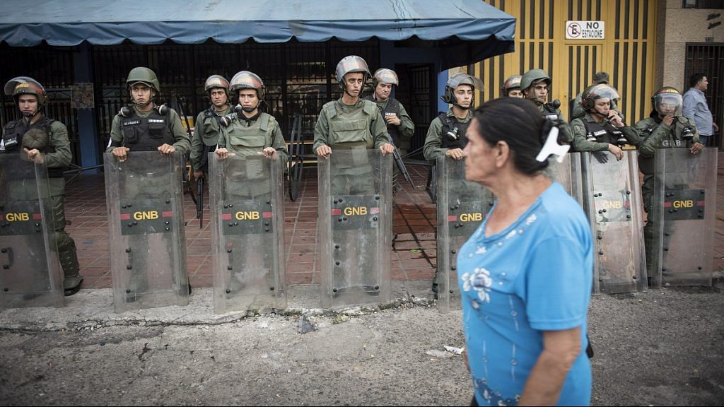 A pedestrian passes by Venezuelan army officers (representational image) | Carlos Becerra/Bloomberg
