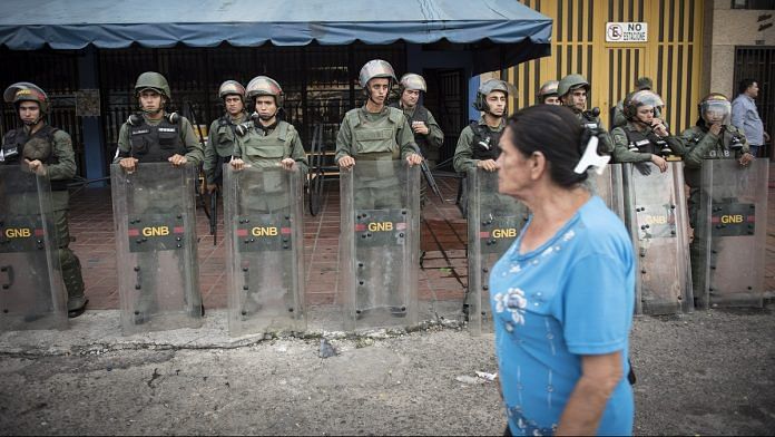 A pedestrian passes by Venezuelan army officers (representational image) | Carlos Becerra/Bloomberg
