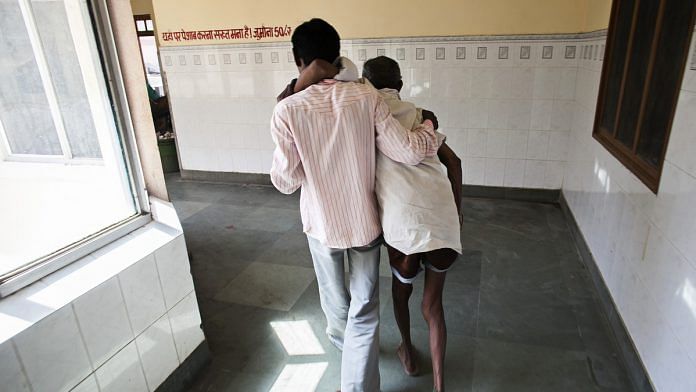 A relative helps a cancer patient to the rest room at Acharya Tulsi Regional Cancer Treatment and Research Institue in Bikaner, Rajasthan | Prashanth Vishwanathan/Bloomberg News