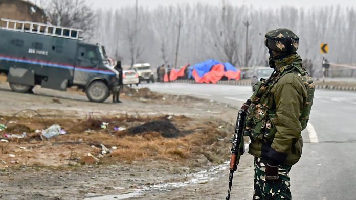 A CRPF soldier stands guard at the site of suicide bomb attack in Pulwama